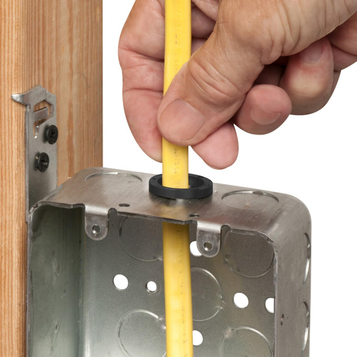Hand installing a yellow electrical cable into a metal electrical box.