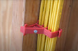Red Wire Staples holding yellow cable against a wooden wall